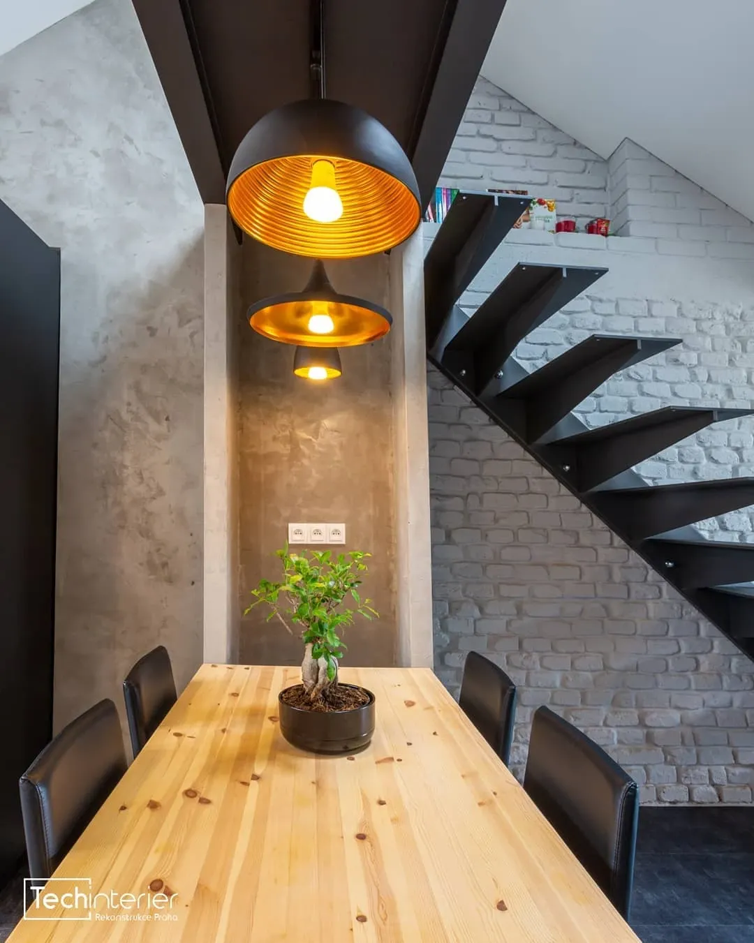 Pudni vestavba s ocelovym schodistem a stolem z masivu v designu Praha